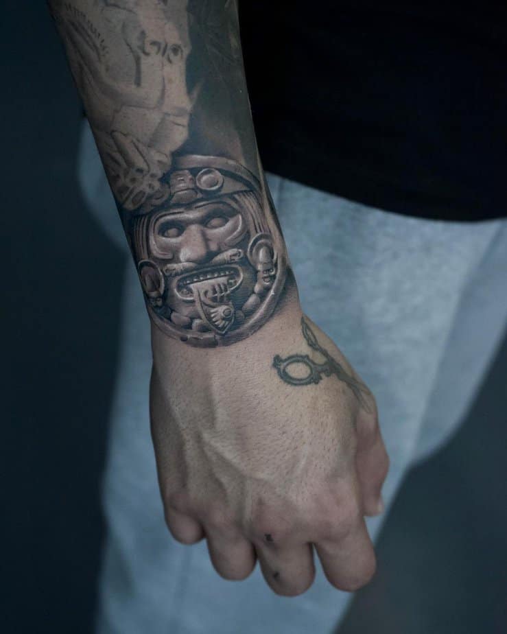 12. Intricate Aztec deity forearm tattoo