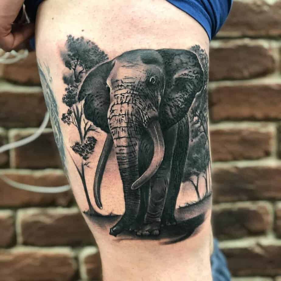 10. Incredibile tatuaggio nero e grigio a forma di elefante sulla coscia per uomini