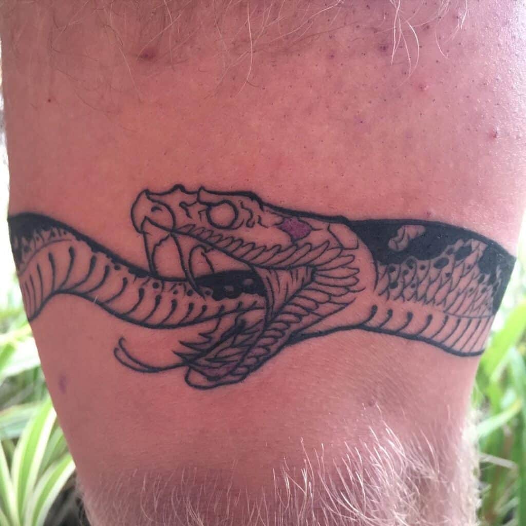 3. Incredibly clean Ouroboros thigh tattoo for men