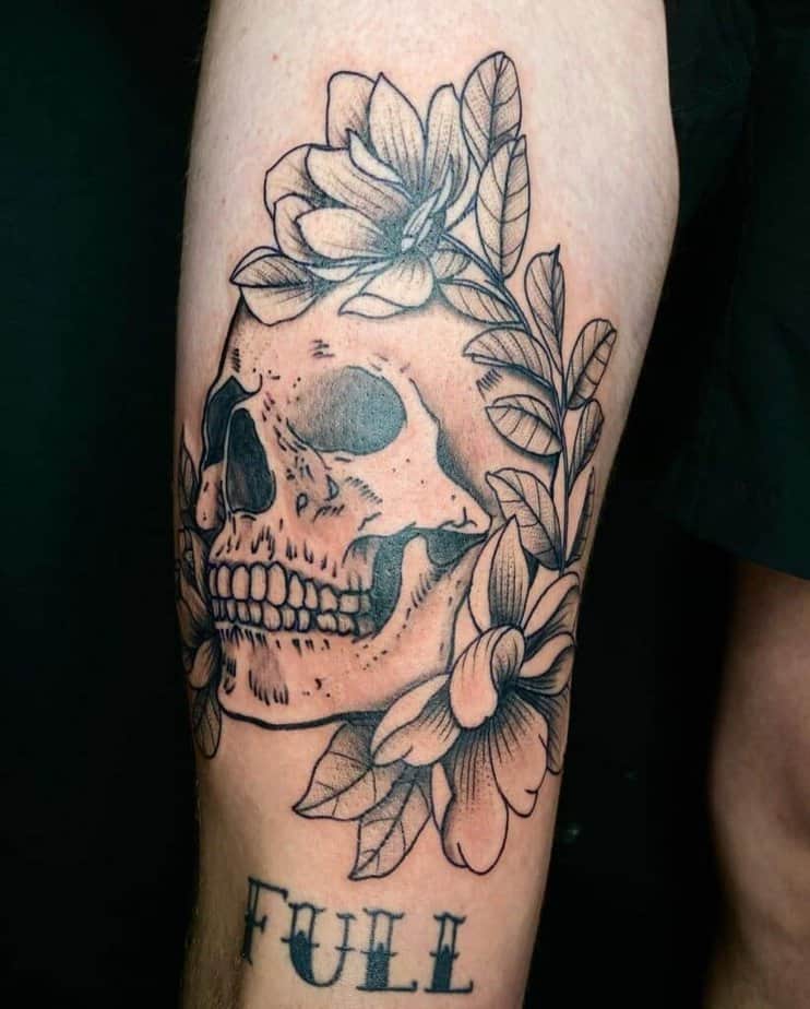 7. A jaw-dropping skull & text thigh tattoo for men