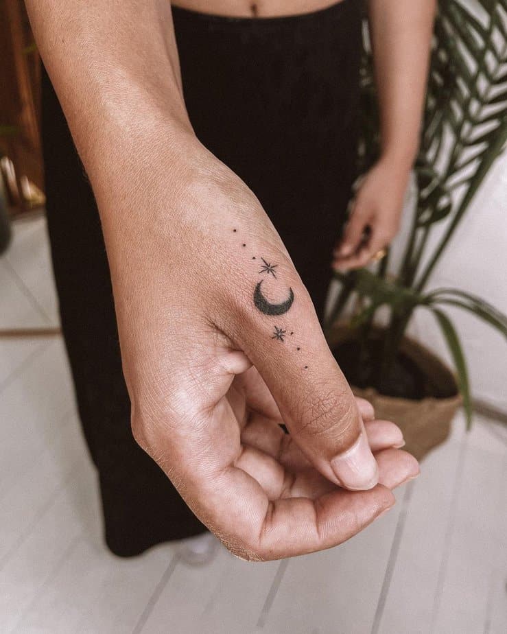 19. A moon and sparkles tattoo on the thumb
