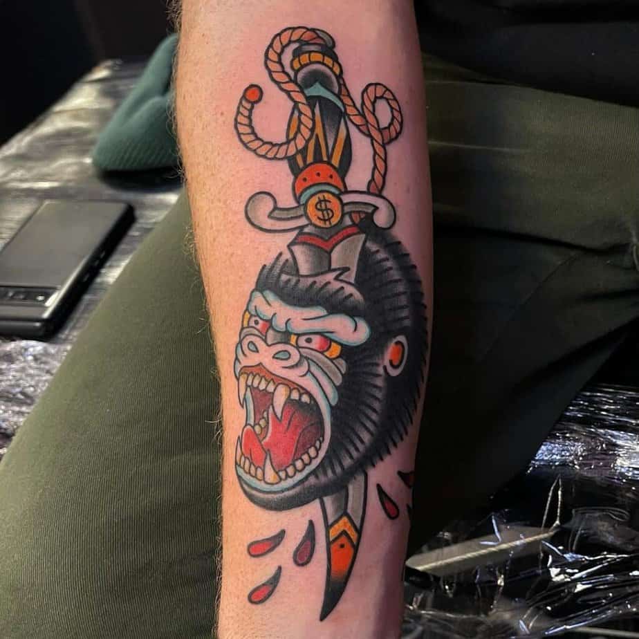 17. A tattoo of a gorilla and a dagger 