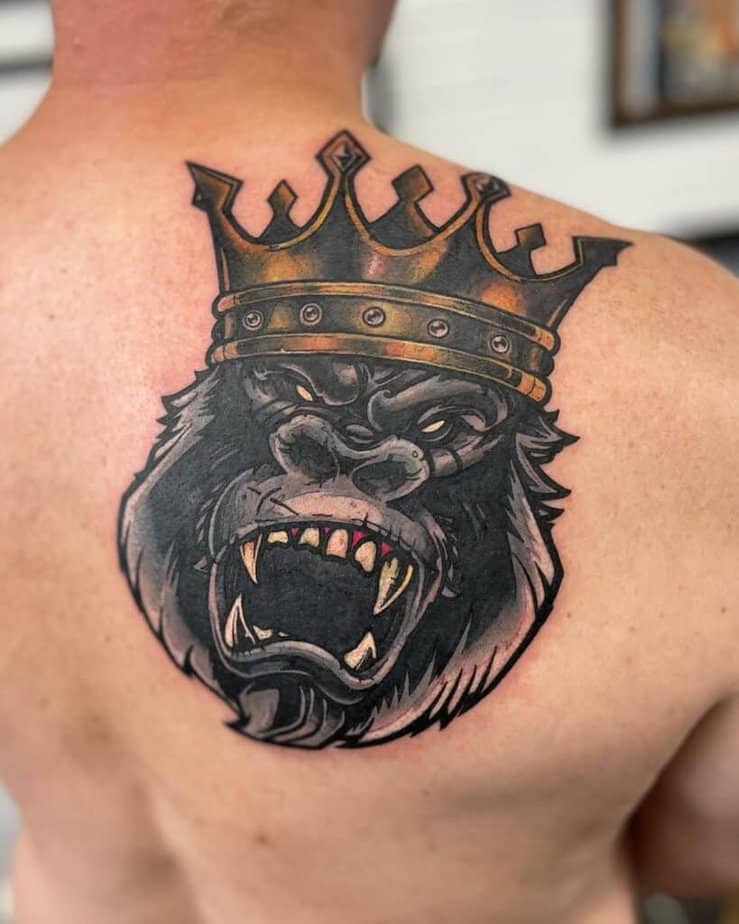 3. A tattoo of a gorilla with a crown on the shoulder blade 