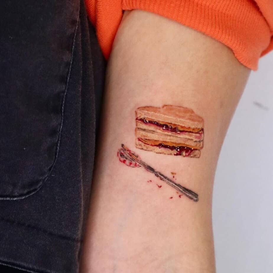 4. Tatuaggio di un sandwich di burro d'arachidi e marmellata sul braccio