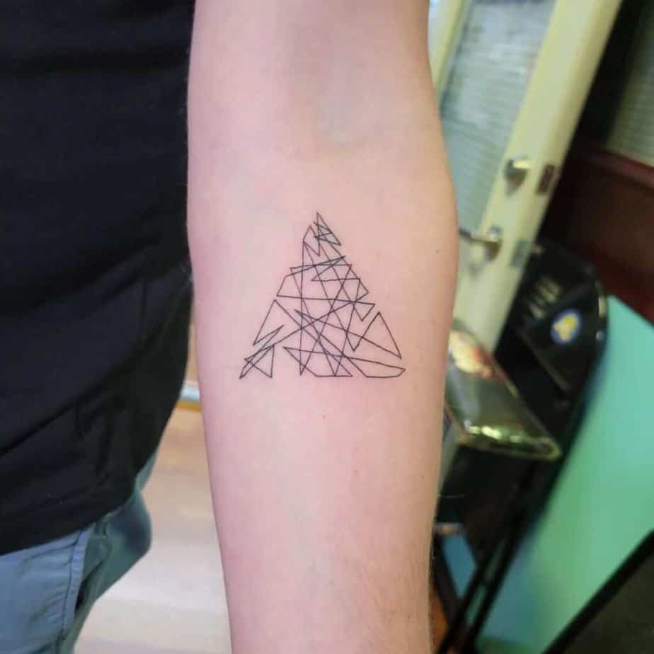 10. A linework triangle tattoo on the forearm