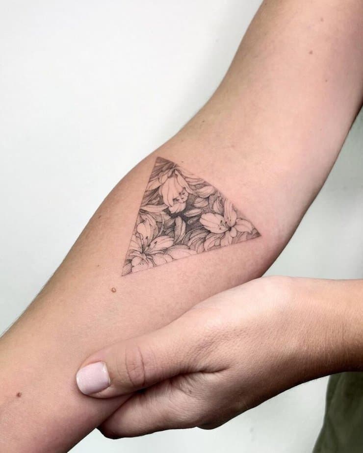 9. A floral triangle tattoo on the forearm