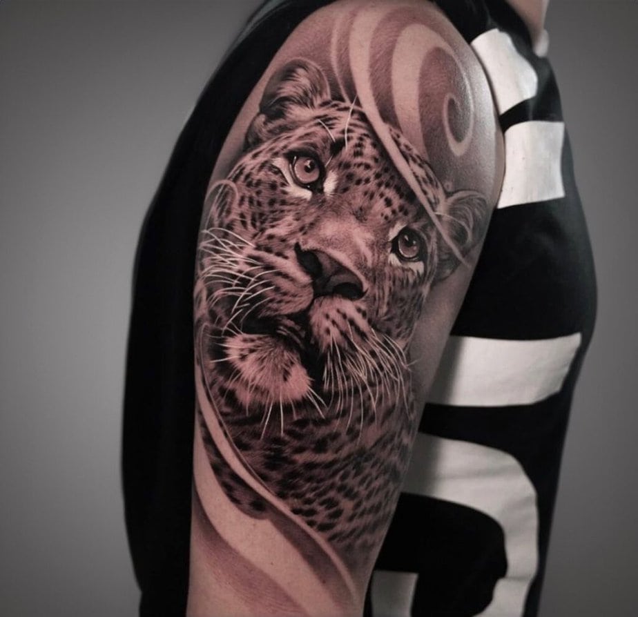 15. Hyper-realistic upper arm leopard tattoo