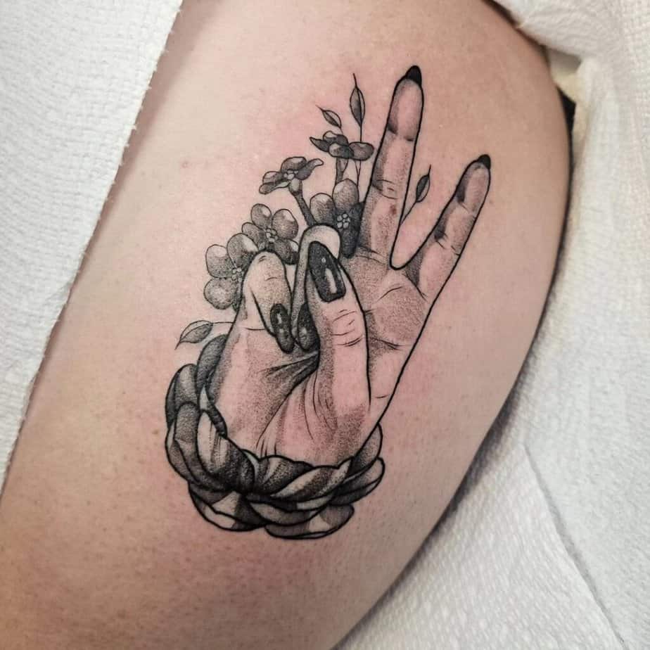 A peace sign tattoo: holding up the hand