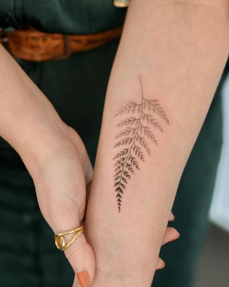 18. A fine-line fern tattoo on the arm
