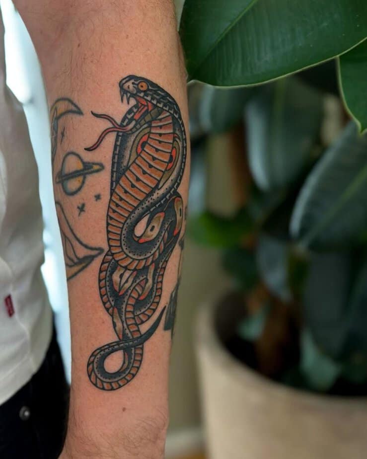 11. A traditional cobra tattoo on the forearm