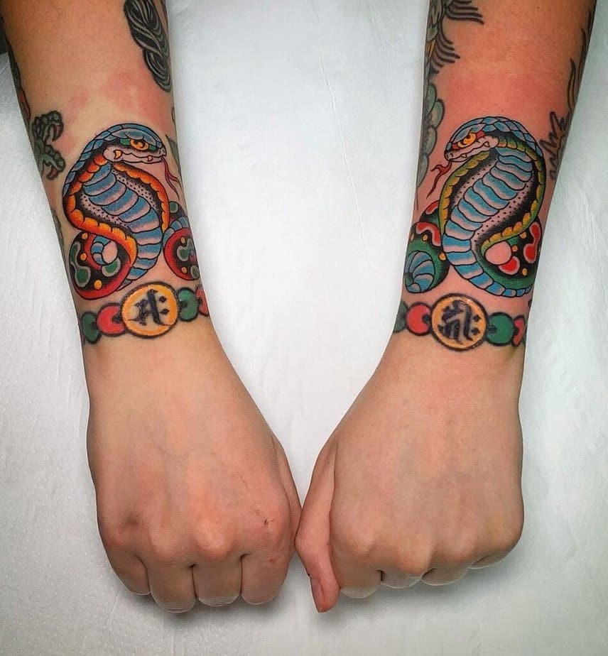 12. Matching cobra tattoos on the wrists 