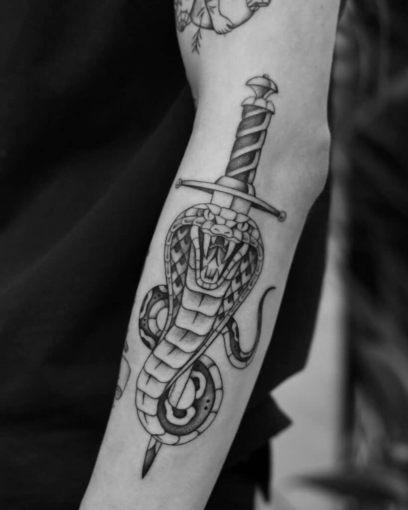 15. A tattoo of a cobra with a dagger