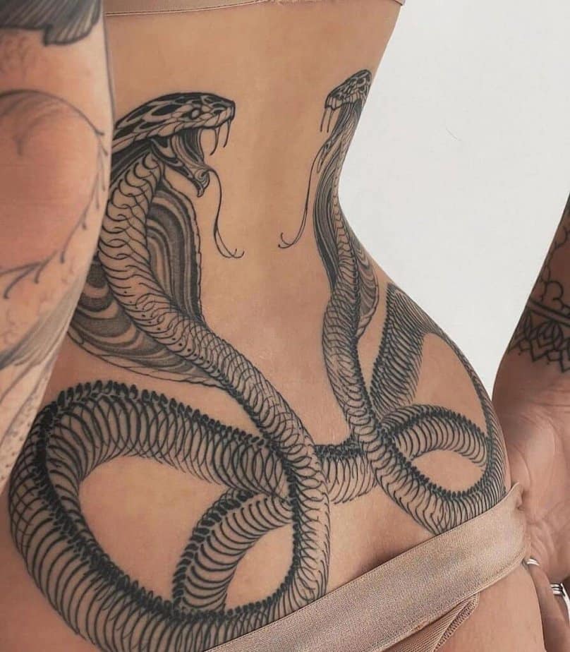 5. A tattoo of two cobras on the lower back