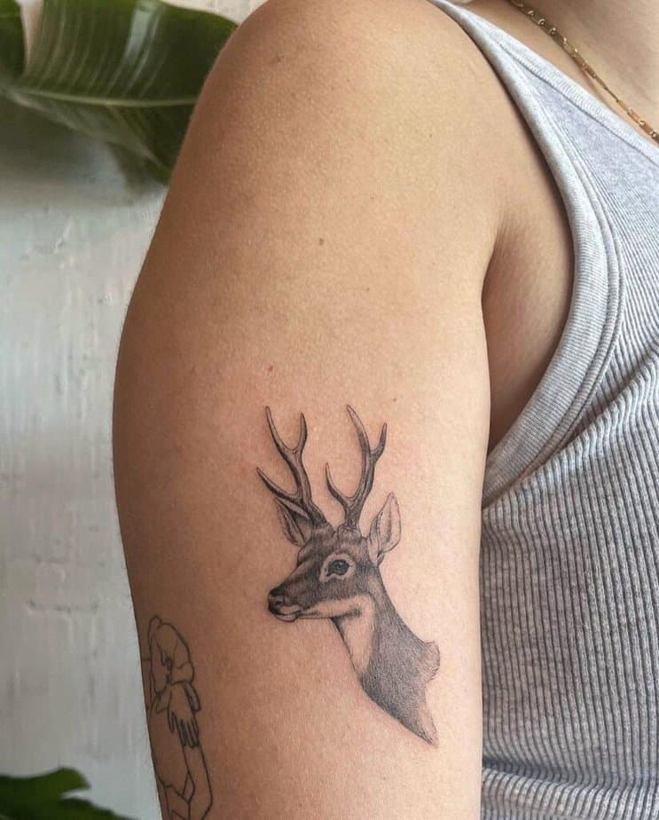 10. A micro-realist deer tattoo on the upper arm