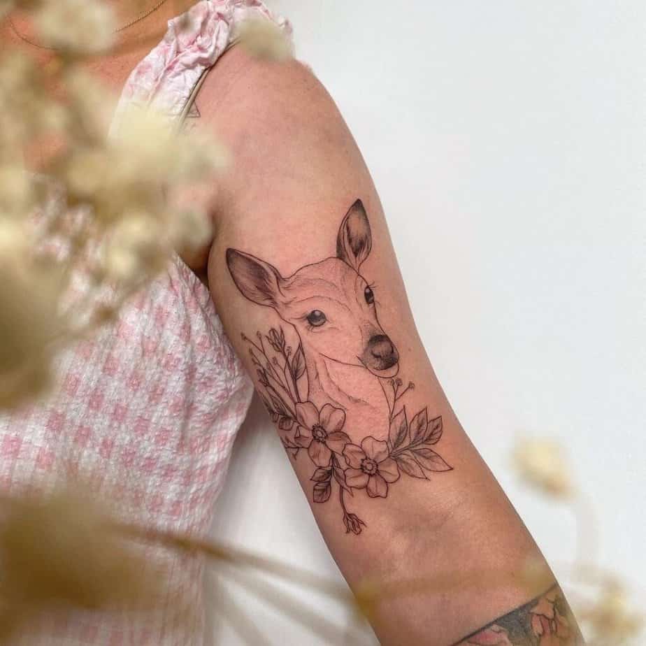 7. A fine-line deer tattoo on the upper arm
