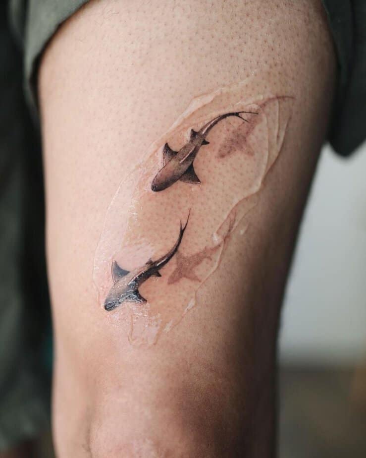 13. Un tatuaggio di due squali sulla coscia