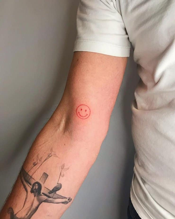 14. A red ink smiley face tattoo