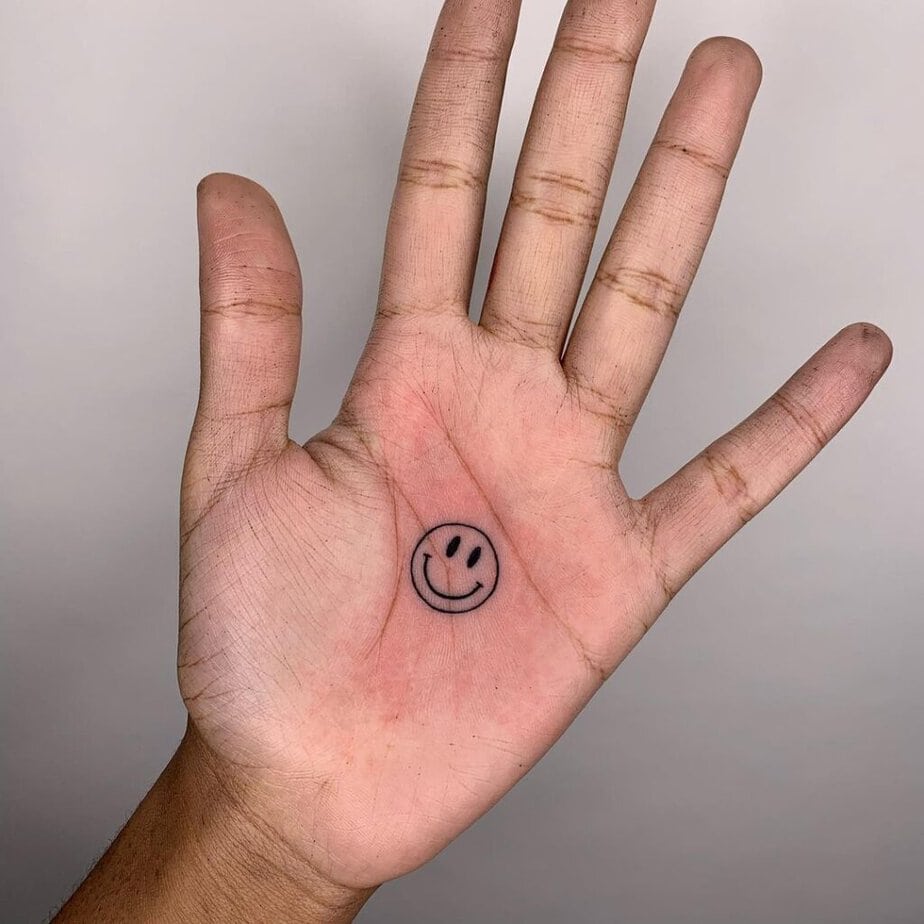 18. Tatuaggio del palmo della mano con faccina sorridente 