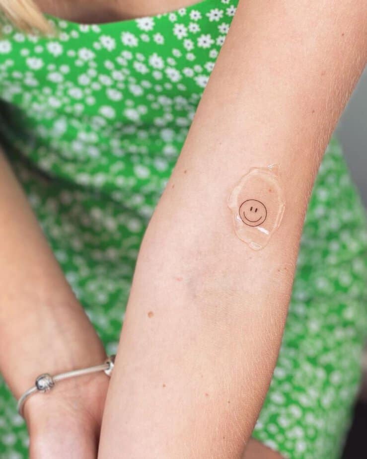 2. A smiley face tattoo on the inside of the arm