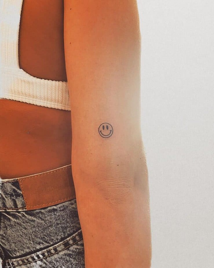 4. A smiley face tattoo on the back of the arm
