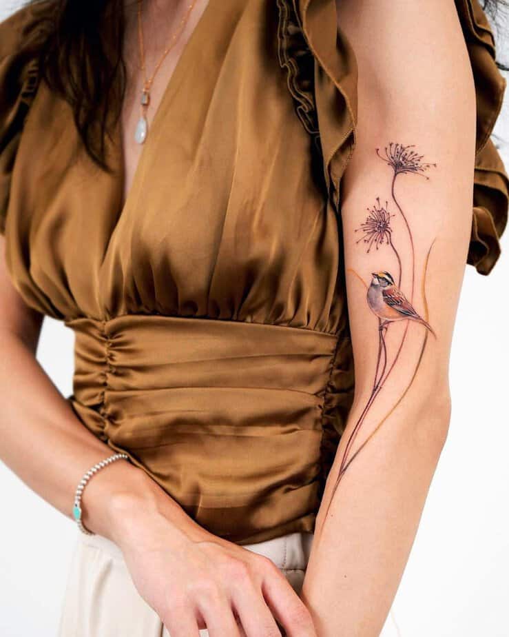 14. A tattoo of a white-throated sparrow sitting on a branch

