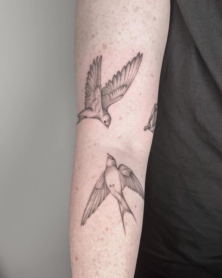 9. A tattoo of two softly shaded sparrows
