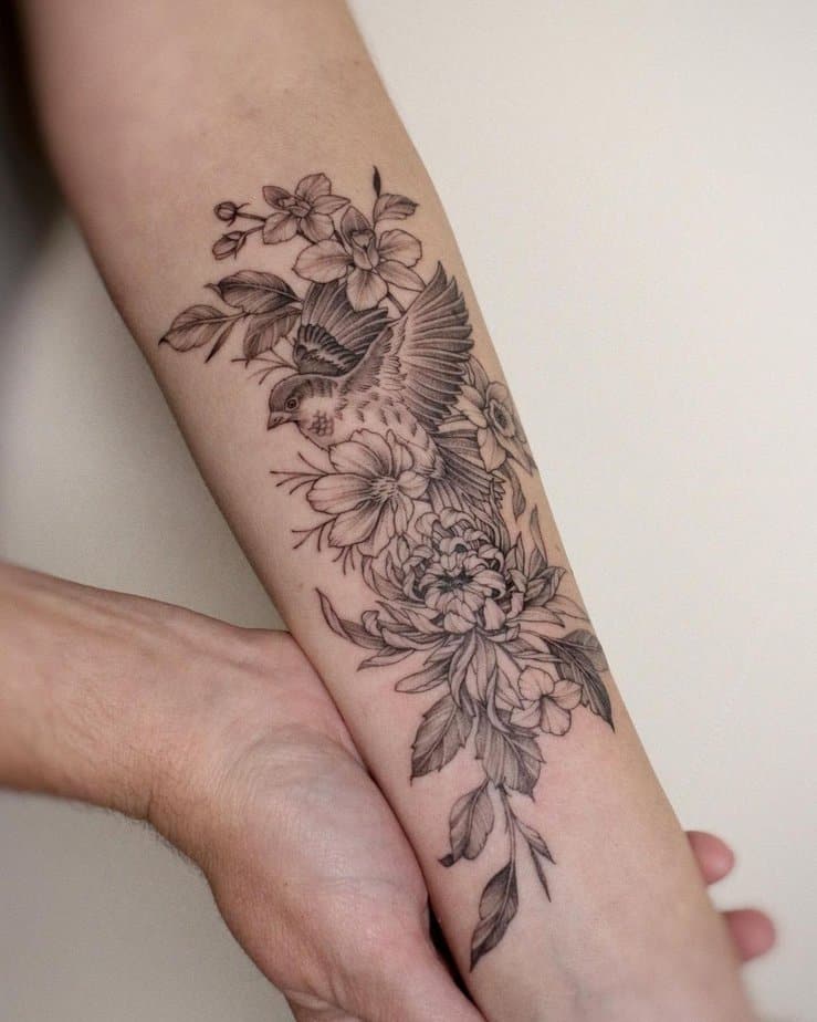 10. A tattoo of a sparrow surrounded by flowers
