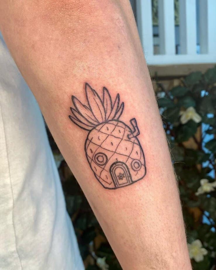 13. A tattoo of the pineapple house on the back of the arm