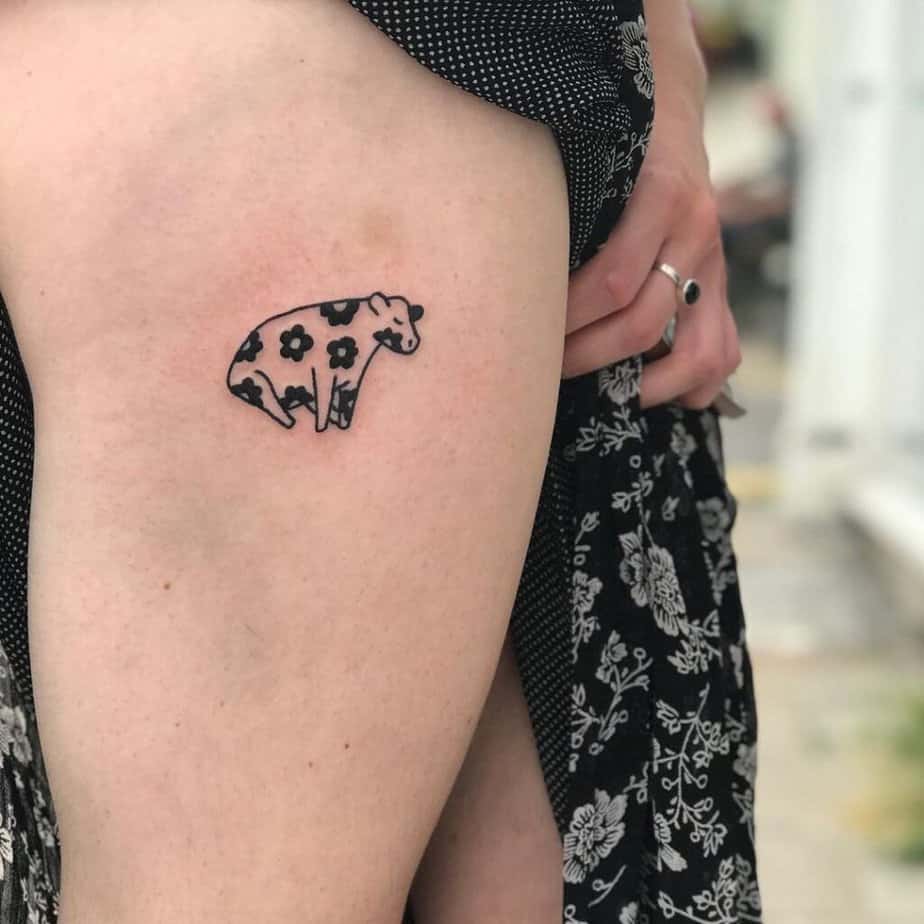 12. Un tatuaggio di una mucca con macchie di fiori