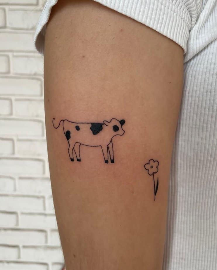3. A simple tattoo of a cow and a flower
