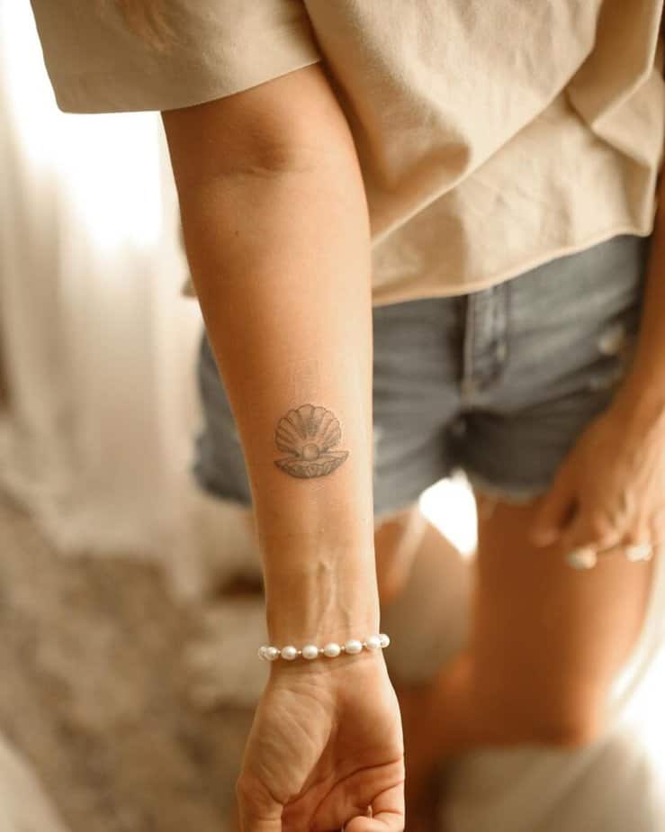 1. Un semplice tatuaggio di conchiglie e perle sul polso