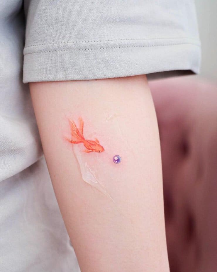 13. A purple pearl tattoo with a goldfish