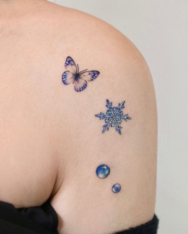 14. A blue pearl tattoo with a butterfly and a snowflake 