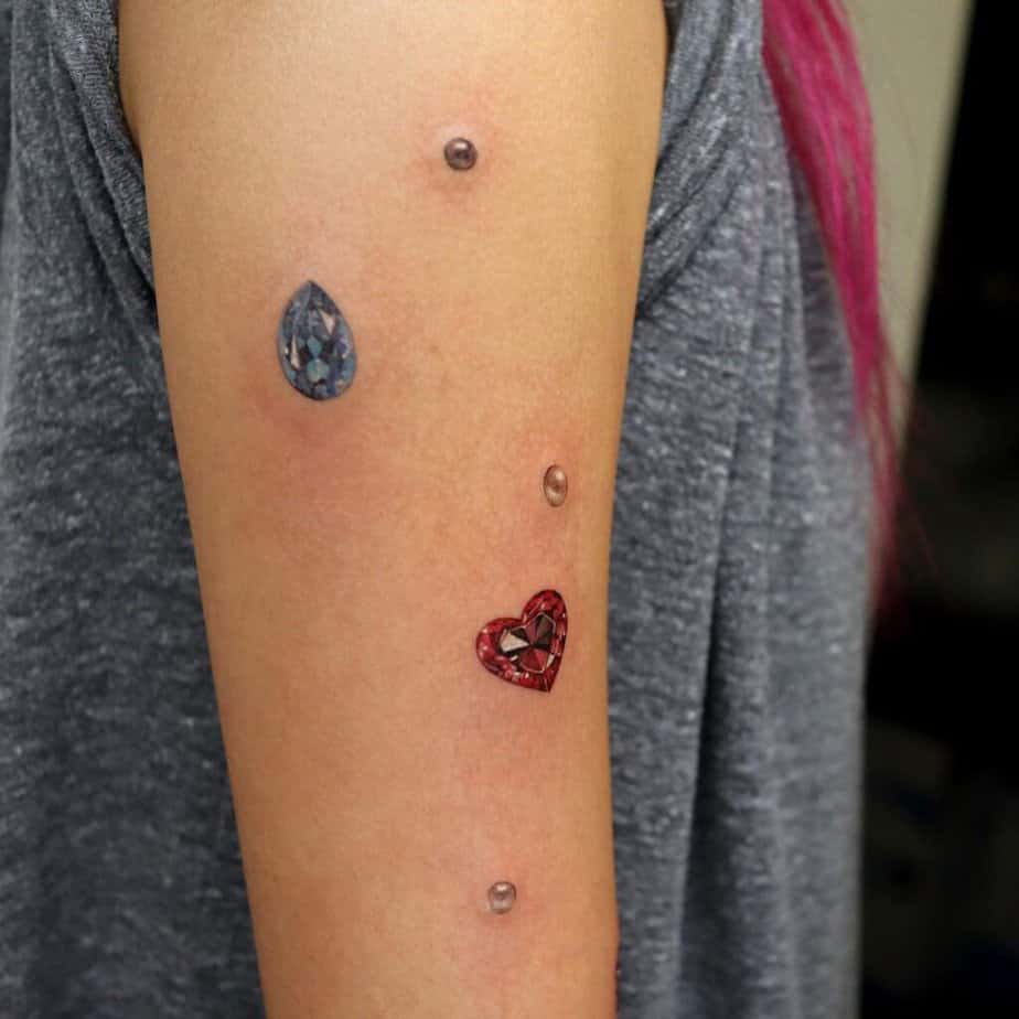 16. A tattoo of pearls and gemstones on the upper arm
