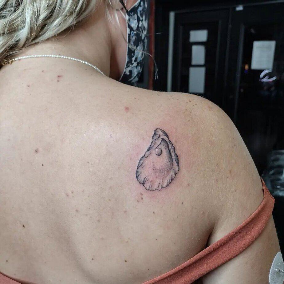 19. A tattoo of an oyster pearl on the back of the shoulder 