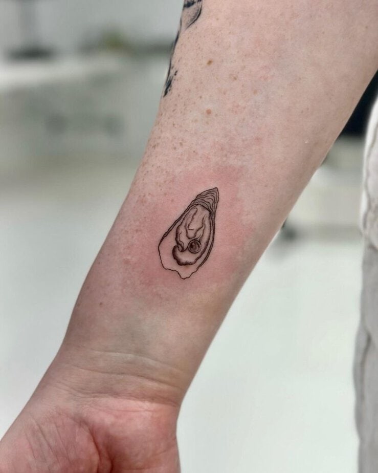 2. A tattoo of an oyster pearl on the wrist