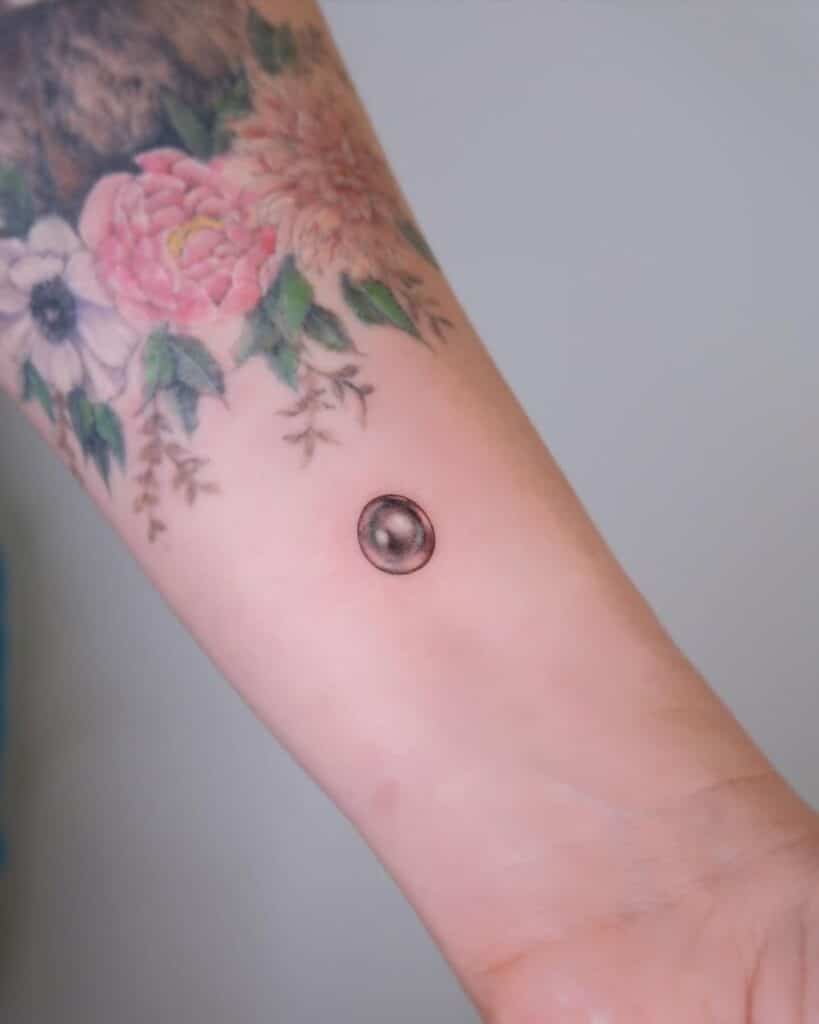 4. Un tatuaggio con una perla nera sul polso