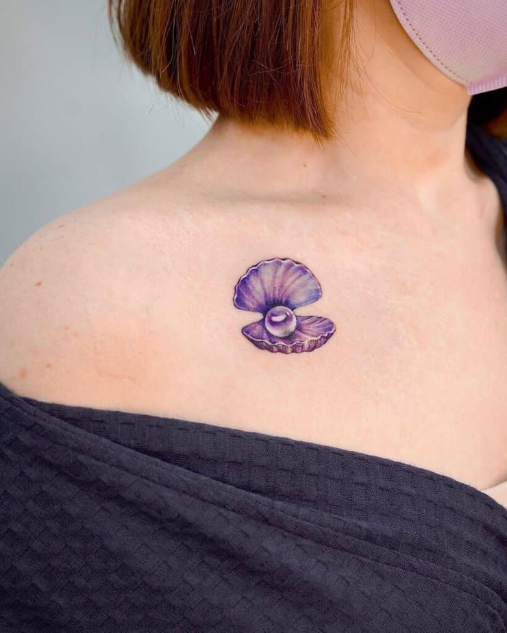 6. Tatuaggio con conchiglia viola e perla sulla clavicola