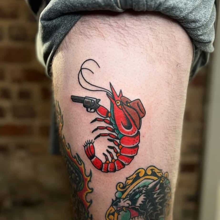 6. A traditional tattoo of a cowboy shrimp with a gun on the thigh