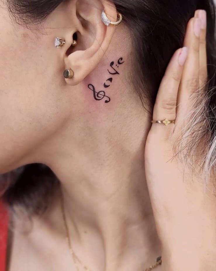11. A musical note tattoo behind the ear