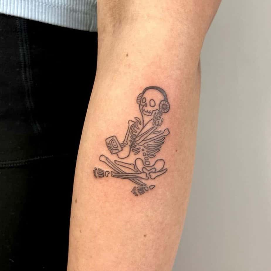 14. A linework tattoo of a skeleton listening to music 