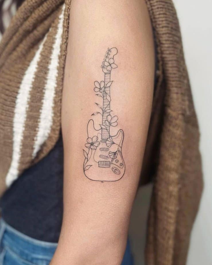 16. A guitar tattoo on the upper arm