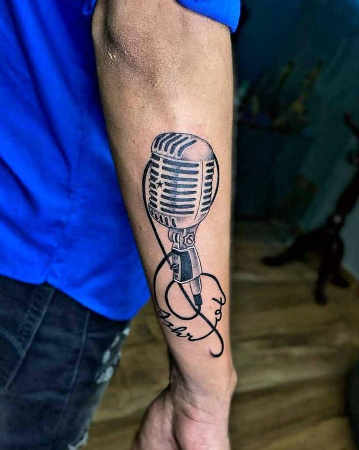 18. Tatuaggio di un microfono sul retro del braccio