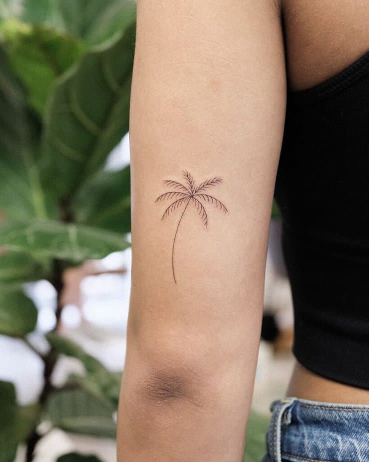 19. Tatuaggio di una palma a linee sottili sulla parte posteriore del braccio.