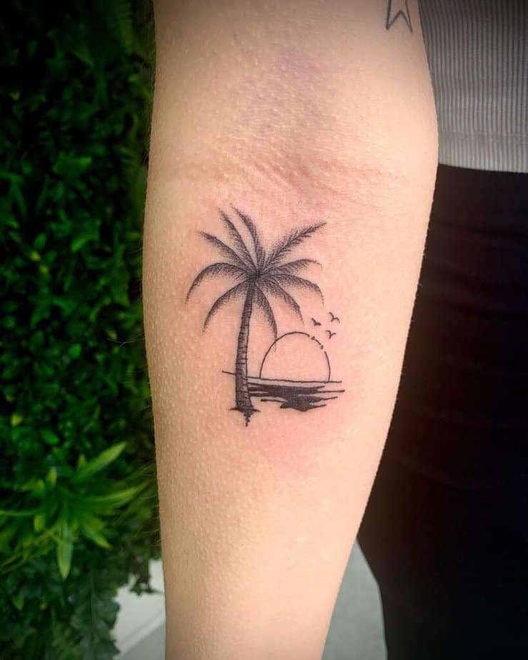 8. A palm tree scene tattoo on the forearm
