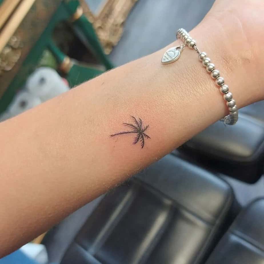 9. A small and simple palm tree tattoo on the arm