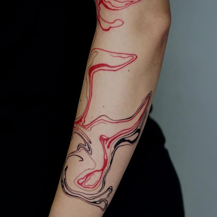 3. A black and red abstract tattoo on the forearm