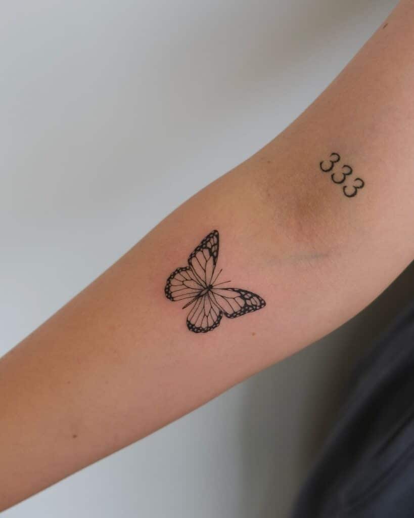 17. Tatuaggio a mano con farfalla e numero d'angelo 