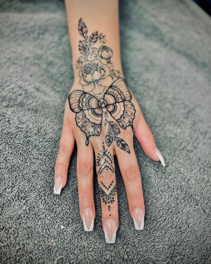18. Tatuaggio a mano con farfalla mandala 