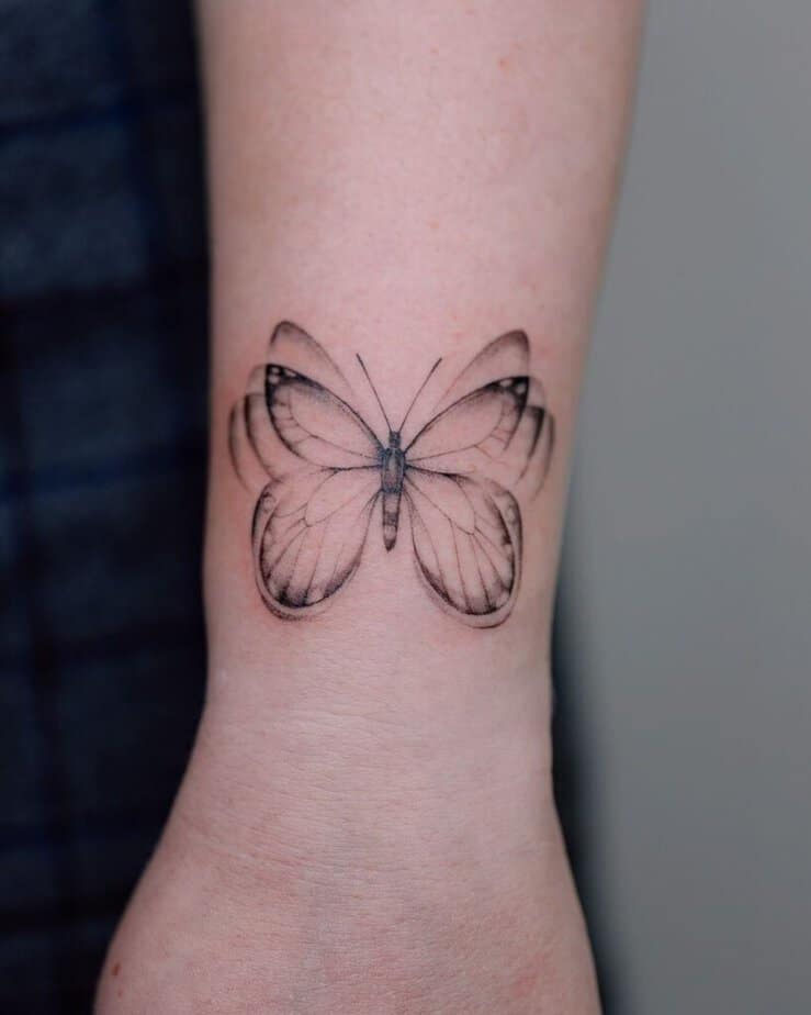 21. A fluttery butterfly hand tattoo 